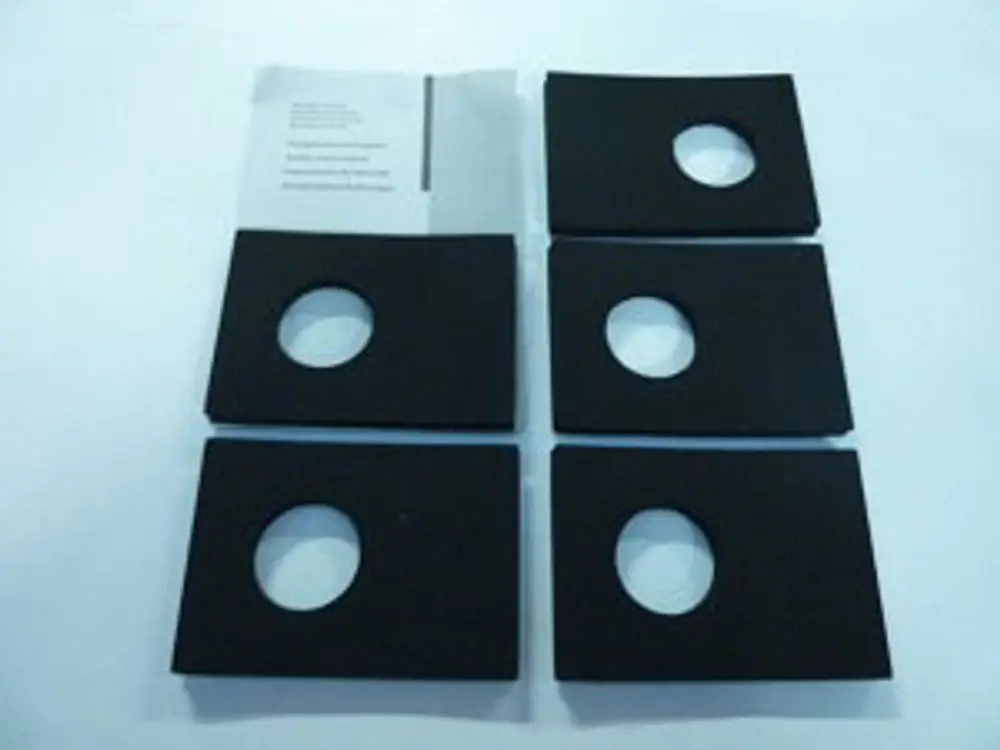 Schwarze Dichtungen mit kreisförmigen Ausschnitten, angeordnet in einer Matrix, daneben eine Anleitung. Produkt von Remeha.